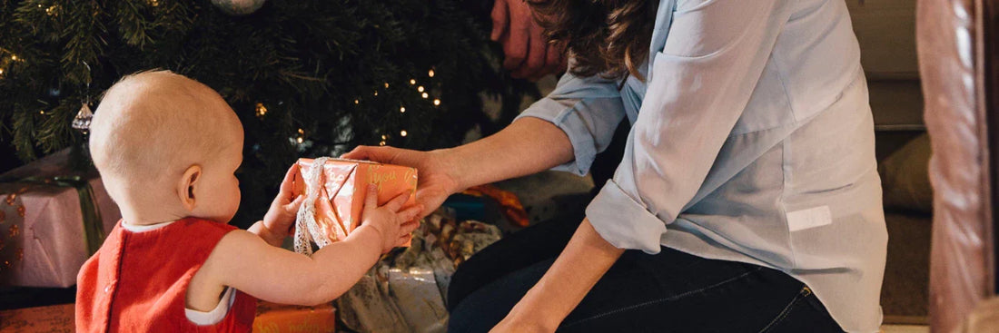 Mother giving baby a Christmas gift 
